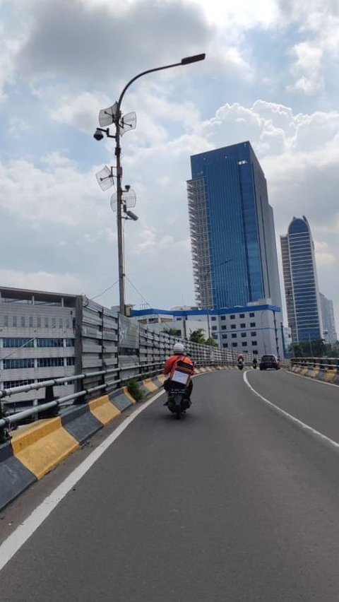 Seorang pengendara motor hampir terkena reruntuhan batu yang jatuh dari flyover Ciputat