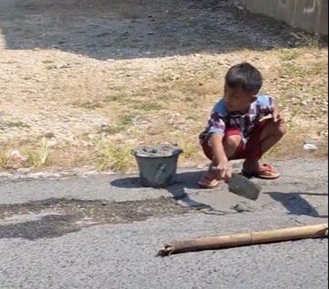 Peduli Jalan Berlubang, Aksi Bocah Tambal Aspal Sendirian Pakai Semen Ini Viral