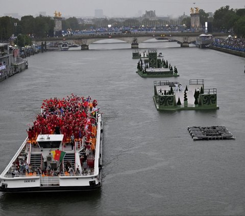 Sebanyak 205 kontingen dari negara-negara peserta mengikuti defile pembukaan yang unik dan spektakuler, dengan menggunakan 85 kapal mereka menyusuri Sungai Seine sejauh 6 kilometer dari jembatan Austerlitz menuju Trocadero, dekat Menara Eiffel. Foto: Hu Huhu / Pool via REUTERS<br>