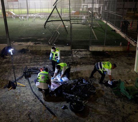 Petugas darurat memeriksa lokasi serangan roket di sebuah lapangan sepak bola di Desa Majdal Shams, Dataran Tinggi Golan yang diduduki Israel, pada Sabtu (27/7/2024). Serangan roket misteirus, yang dilaporkan berasal dari Lebanon, tersebut menewaskan sedikitnya 11 orang. Sementara, sebanyak 19 orang terluka. Foto: REUTERS/Ammar Awad