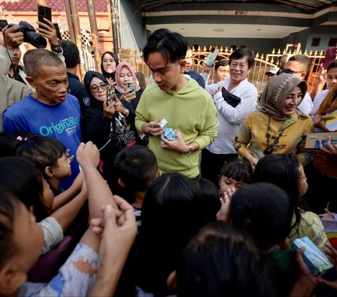 Wakil Presiden terpilih RI, Gibran Rakabuming Raka melakukan blusukan di sebuah permukiman di Jakarta, pada Rabu (3/7/2024). Dalam kesempatan tersebut, Gibran membagi-bagikan buku dan susu gratis kepada anak-anak yang ditemuinya. Foto: Bay Ismoyo/AFP