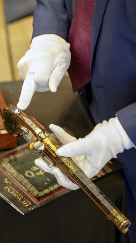 Kedua pistol tersebut memiliki hiasan mewah dengan tatanan emas dan perak yang menampilkan ukiran gambar Napoleon dalam kemegahan kekaisaran. Geoffroy Van Der Hasselt/AFP