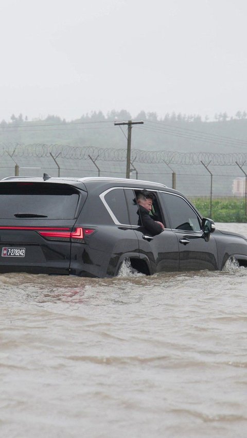 Kim Jong-un terlihat menerjang genangan banjir menggunakan SUV mewah miliknya untuk melihat langsung dampak banjir yang dipicu tingginya curah hujan tersebut. Foto: KCNA/AFP