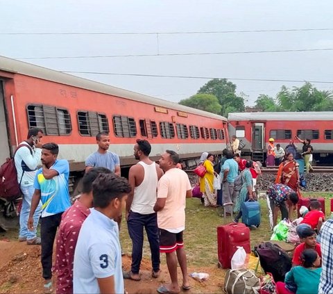 Sejumlah penumpang dengan barang bawaannya berkumpul di dekat kereta penumpang Howrah-Mumbai Express yang tergelincir di dekat Chakradharpur, negara bagian Jharkhand, India, pada Selasa (307/2024). Insiden ini menewaskan sedikitnya 2 orang penumpang dan menyebabkan 20 lainnya terluka. Foto: Rajesh Kumar/AFP