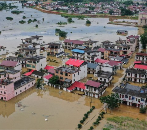 Banjir ini menyebabkan banyak warga terjebak di rumah-rumah mereka, dengan air yang menggenangi sekeliling rumah hingga ketinggian yang mengkhawatirkan. Foto: STRINGER / AFP<br>