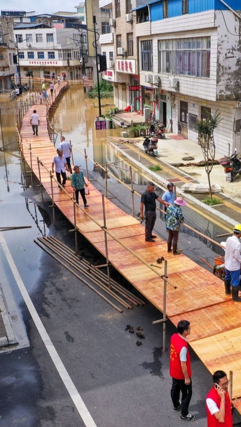 Jembatan darurat ini terdiri dari rangkaian pipa besi yang kokoh dan jalur yang terbuat dari papan kayu. Foto: STR / AFP<br>