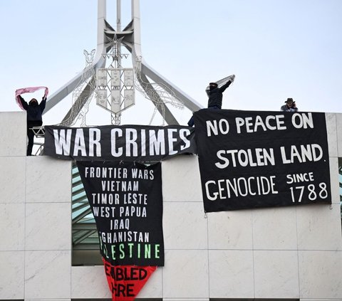 Sekelompok demonstran pro-Palestina berhasil memanjat Gedung Parlemen di Canberra.<br><br>Mereka membentangkan sejumlah spanduk sebagai bentuk dukungan terhadap Palestina. Foto: REUTERS / Tracey Nearmy<br>