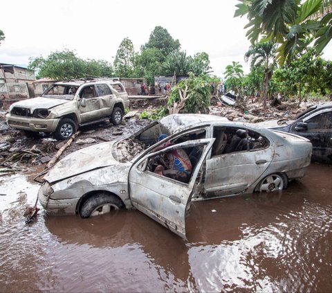 Seorang pria memeriksa sebuah mobil yang hancur  setelah banjir dahsyat menerjang Cumanacoa, Venezuela, pada 2 Juli 2024. Terjangan banjir dahsyat itu terjadi setelah Badai Beryl melanda wilayah lepas pantai Venezuela. REUTERS/Samir Aponte