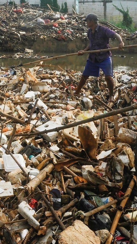 Warga memilah sampah yang dapat didaur ulang pada tumpukan sampah yang dibawa aliran Sungai Pesanggrahan di Jembatan Kampung Bulak barat-Pasir Putih, Depok, Jawa Barat, Minggu (07/07/2024).  Sampah rumah tangga yang dibawa aliran Kali Pesanggrahan sejak kemarin disebabkan kurangnya kesadaran warga untuk menjaga kebersihan sungai.