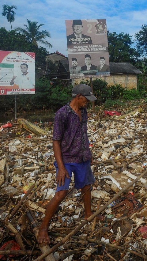 Warga memilah sampah yang dapat didaur ulang pada tumpukan sampah yang dibawa aliran Sungai Pesanggrahan di Jembatan Kampung Bulak barat-Pasir Putih, Depok, Jawa Barat, Minggu (07/07/2024).  Sampah rumah tangga yang dibawa aliran Kali Pesanggrahan sejak kemarin disebabkan kurangnya kesadaran warga untuk menjaga kebersihan sungai.