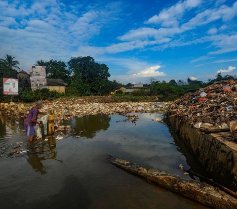 Warga memilah sampah yang dapat didaur ulang pada tumpukan sampah yang dibawa aliran Sungai Pesanggrahan di Jembatan Kampung Bulak barat-Pasir Putih, Depok, Jawa Barat, Minggu (07/07/2024).  Sampah rumah tangga yang dibawa aliran Kali Pesanggrahan sejak kemarin disebabkan kurangnya kesadaran warga untuk menjaga kebersihan sungai.