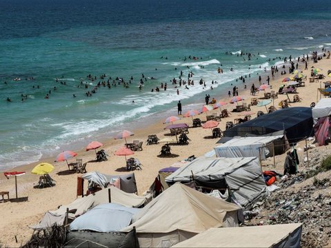 FOTO: Usai Dipaksa Evakuasi Massal Oleh Israel, Pengungsi Palestina Berlindung di Pantai Gaza, Ancaman Tersapu Ombak Menghantui