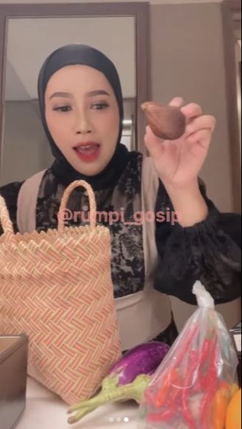 Selain sayuran, wanita itu juga mengambil buah salak satu biji.