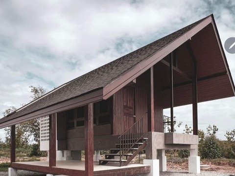 Rumah Kayu dengan Atap Miring dan Warna Kayu Gelap