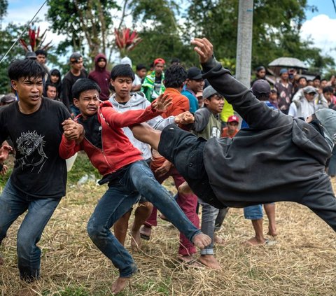 Meski terlihat seperti duel maut, ritual ini dilaksanakan dengan penuh kesenangan dan semangat kebersamaan.Para peserta melompat dan mengayunkan kaki setinggi mungkin untuk menjatuhkan lawan. Para peserta dilarang menggunakan tangan, memukul, atau menampar. Foto: Hariandi Hafid / AFP