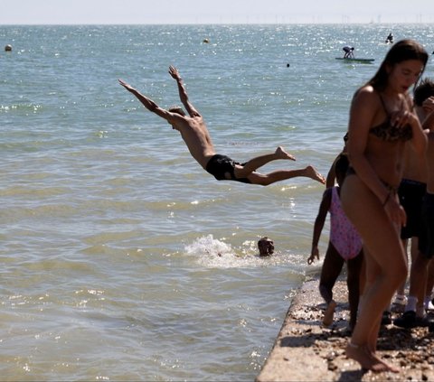 FOTO: Tak Peduli dengan Gelombang Panas, Ribuan Warga Inggris Tetap Asyik Berjemur Padati Tepi Danau dan Pantai