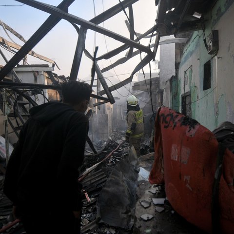 Petugas pemadam kebakaran melakukan pendinginan area pemukiman penduduk yang terbakar di Kawasan Manggarai, Jakarta, Selasa (13/8/2024).