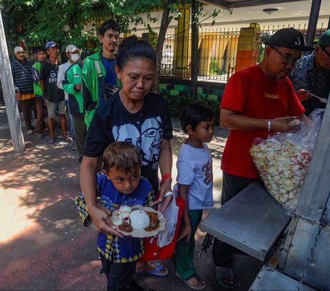 Warga antre mendapatkan sepiring nasi sayur dan lauk pauk saat pembagian makan siang gratis di wilayah Jati Padang, Pasar Minggu, Jakarta Selatan, Selasa (13/08/2024).