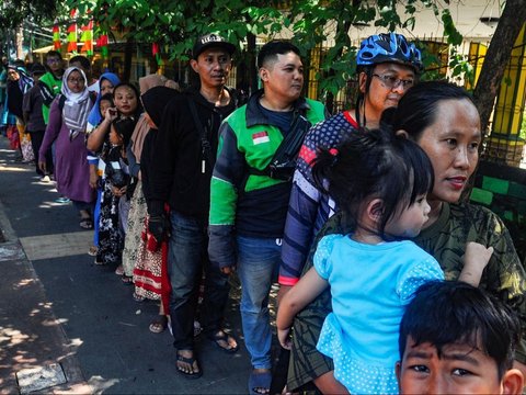 Warga antre mendapatkan sepiring nasi sayur dan lauk pauk saat pembagian makan siang gratis di wilayah Jati Padang, Pasar Minggu, Jakarta Selatan, Selasa (13/08/2024).