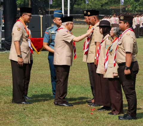 Wakil Presiden Ma`ruf Amin (tengah) didampingi Ketua Kwartir Nasional (Kwarnas) Pramuka Budi Waseso (kiri) menyematkan tanda penghargaan kepada anggota Pramuka di Bumi Perkemahan dan Graha Wisata (Buperta) Cibubur, Jakarta, Rabu (14/8/2024). Dalam perayaan Hari Pramuka ke-63, Ma'ruf Amin bertindak langsung sebagai pembina upacara. Foto: Liputan6.com/Herman Zakharia