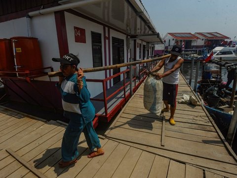 Nelayan melihat rumahnya yang sudah direnovasi menjadi rumah apung di kampung nelayan Muara Angke, Jakarta Utara, Rabu (14/08/2024). 200 Rumah nelayan yang tadinya kumuh kini diubah menjadi rumah apung bantuan dari Universitas Pertahanan yang diinisiasi Prabowo Subianto sebagai upaya meningkatkan kesejahteraan warga nelayan yang kerap terdampak bencana banjir rob dan abrasi. Merdeka.com/Arie Basuki