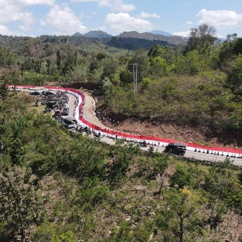 Ratusan warga Kecamatan Musi, Kabupaten Timor Tengah Utara (TTU), Nusa Tenggara Timur (NTT) bersama TNI-Polri dan Pemerintah Kecamatan membentang bendera raksasa di sepanjang jalan sabuk merah.