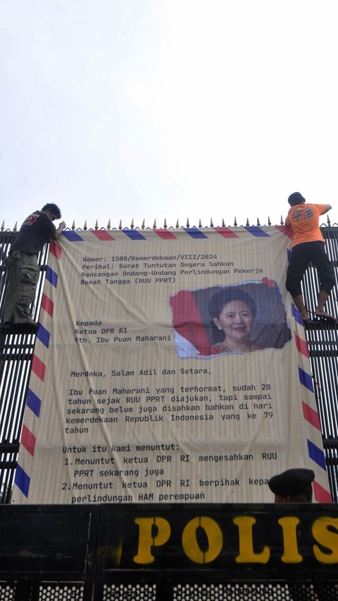 Dalam aksi unjuk rasa pada Kamis (15/8), massa membentangkan surat tuntutan raksasa pada pintu gerbang Gedung DPR. Foto: Merdeka.com/Imam Buhori