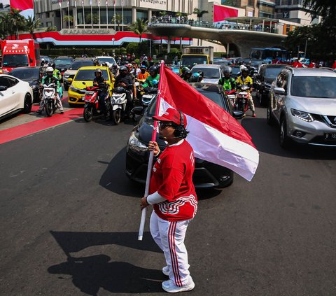 Seorang pria membawa bendera merah putih saat peringatan HUT ke-79 Kemerdekaan RI di kawasan Bundaran HI, Jakarta, Sabtu (17/8/2024). Peringatan HUT ke-79 Kemerdekaan RI turut menarik perhatian para pengendara dan pejalan kaki yang melintas di kawasan Bundaran HI. Foto: Liputan6.com/Angga Yuniar