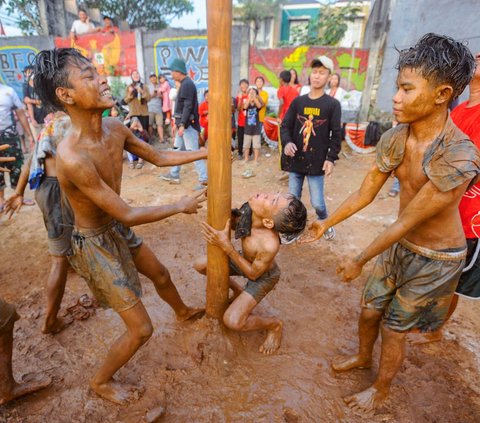 FOTO: Ragam Ekspresi Peserta Panjat Pinang Meriahkan Peringatan HUT RI di Tangerang Selatan