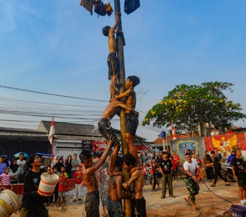 FOTO: Ragam Ekspresi Peserta Panjat Pinang Meriahkan Peringatan HUT RI di Tangerang Selatan