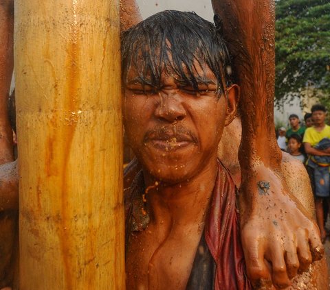 FOTO: Ragam Ekspresi Peserta Panjat Pinang Meriahkan Peringatan HUT RI di Tangerang Selatan