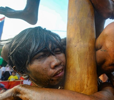 FOTO: Ragam Ekspresi Peserta Panjat Pinang Meriahkan Peringatan HUT RI di Tangerang Selatan