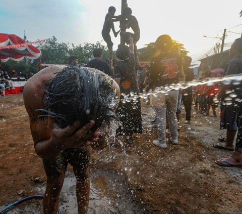 FOTO: Ragam Ekspresi Peserta Panjat Pinang Meriahkan Peringatan HUT RI di Tangerang Selatan