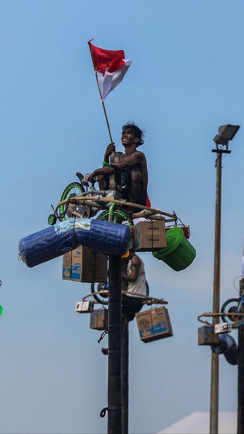 FOTO: Semarakkan HUT RI, Ratusan Orang Ikuti Lomba Panjat Pinang di Ancol Taman Impian