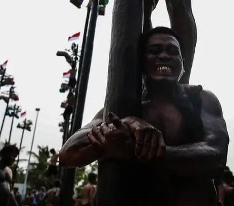 FOTO: Semarakkan HUT RI, Ratusan Orang Ikuti Lomba Panjat Pinang di Ancol Taman Impian