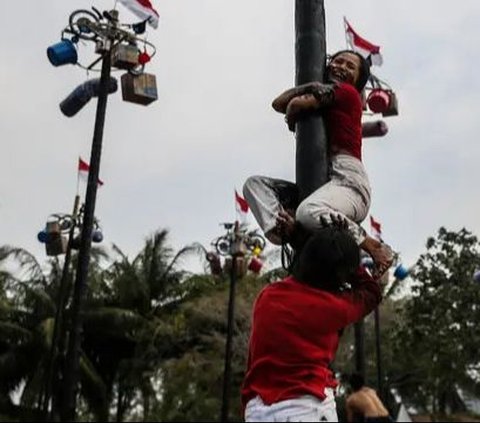 FOTO: Semarakkan HUT RI, Ratusan Orang Ikuti Lomba Panjat Pinang di Ancol Taman Impian