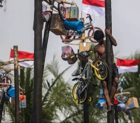 FOTO: Semarakkan HUT RI, Ratusan Orang Ikuti Lomba Panjat Pinang di Ancol Taman Impian