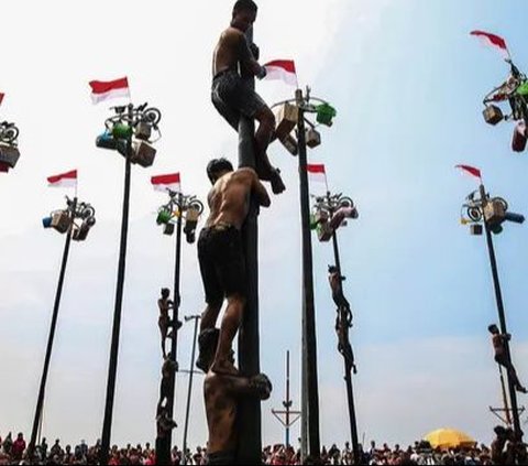 Peserta mengikuti lomba panjat pinang di Pantai Ancol, Jakarta, Sabtu (17/8/2024). Dalam rangka menyemarakkan HUT ke-79 Kemerdekaan RI, Ancol menghadirkan sebanyak 53 pohon pinang untuk diperlombakan. Foto: Liputan6.com/Angga Yuniar