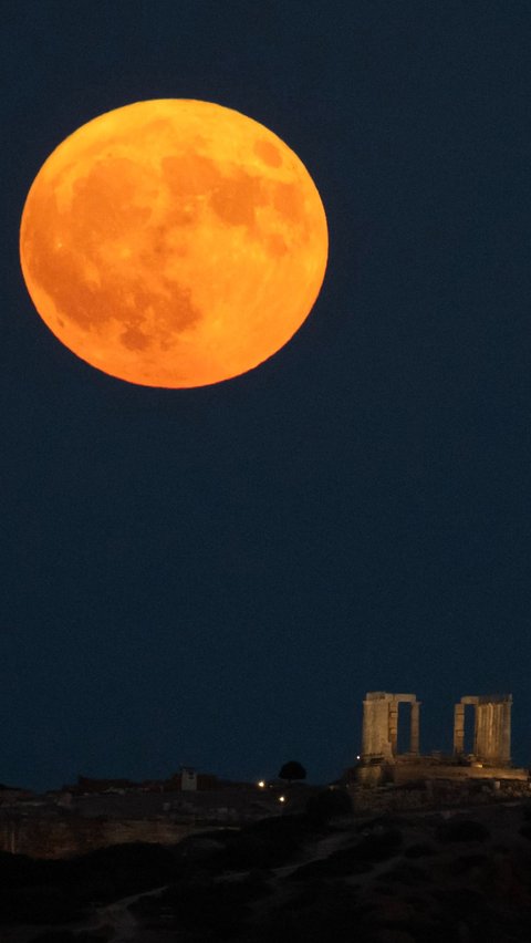 Supermoon langka terlihat di atas kuil kuno Poseidon, Tanjung Sounion, sebelah selatan Athena, Yunani, pada Senin (19/8/2024). Foto: Angelos Tzortzinis/AFP