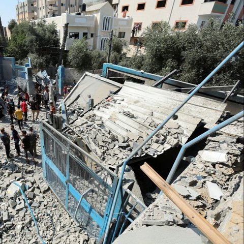 Warga Palestina berkumpul di lokasi serangan udara Israel di sekolah Abu Oreiban yang dikelola oleh UNRWA (Badan PBB untuk Pengungsi) di Kamp Nuseirat pada Minggu (14/7/2024). Serangan tersebut terjadi di tengah konflik yang terus memanas antara Israel dan Hamas.