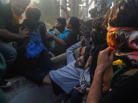 Mahasiswa terjatuh saat bentrok dengan aparat di depan Gedung DPR/MPR, jakarta, kamis (22/08/2024). Bentrok pada beberapa titik di kawasan gedung DPR/MPR saat mahasiswa menjebol pagar gedung.