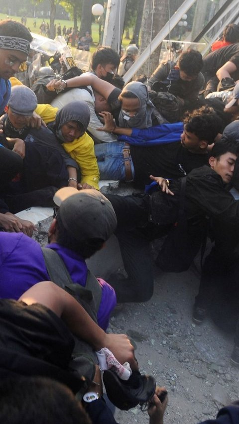 Mahasiswa terjatuh saat bentrok dengan aparat di depan Gedung DPR/MPR, jakarta, kamis (22/08/2024). Bentrok pada beberapa titik di kawasan gedung DPR/MPR saat mahasiswa menjebol pagar gedung.