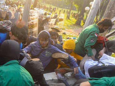 Mahasiswa terjatuh saat bentrok dengan aparat di depan Gedung DPR/MPR, jakarta, kamis (22/08/2024). Bentrok pada beberapa titik di kawasan gedung DPR/MPR saat mahasiswa menjebol pagar gedung.