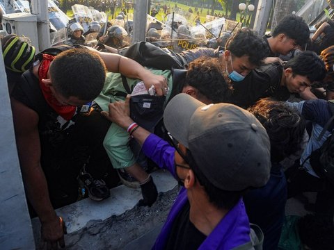 Mahasiswa terjatuh saat bentrok dengan aparat di depan Gedung DPR/MPR, jakarta, kamis (22/08/2024). Bentrok pada beberapa titik di kawasan gedung DPR/MPR saat mahasiswa menjebol pagar gedung.