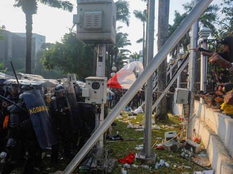 Mahasiswa terjatuh saat bentrok dengan aparat di depan Gedung DPR/MPR, jakarta, kamis (22/08/2024). Bentrok pada beberapa titik di kawasan gedung DPR/MPR saat mahasiswa menjebol pagar gedung.