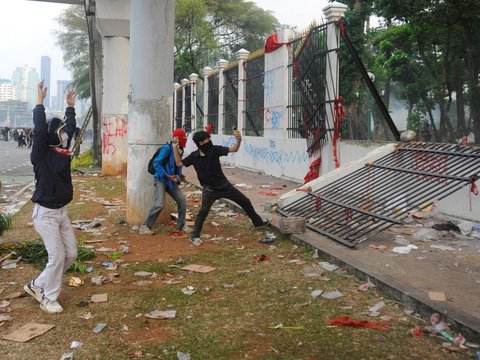 Mahasiswa terjatuh saat bentrok dengan aparat di depan Gedung DPR/MPR, jakarta, kamis (22/08/2024). Bentrok pada beberapa titik di kawasan gedung DPR/MPR saat mahasiswa menjebol pagar gedung.