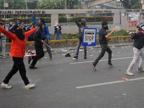 Mahasiswa terjatuh saat bentrok dengan aparat di depan Gedung DPR/MPR, jakarta, kamis (22/08/2024). Bentrok pada beberapa titik di kawasan gedung DPR/MPR saat mahasiswa menjebol pagar gedung.