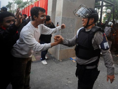Mahasiswa terjatuh saat bentrok dengan aparat di depan Gedung DPR/MPR, jakarta, kamis (22/08/2024). Bentrok pada beberapa titik di kawasan gedung DPR/MPR saat mahasiswa menjebol pagar gedung.