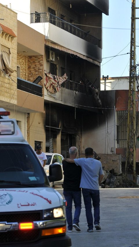 Terlihat sebuah bangunan tempat tinggal yang hangus sebagian usai terkena hantaman serangan udara Israel di Sidon. Foto: AFP