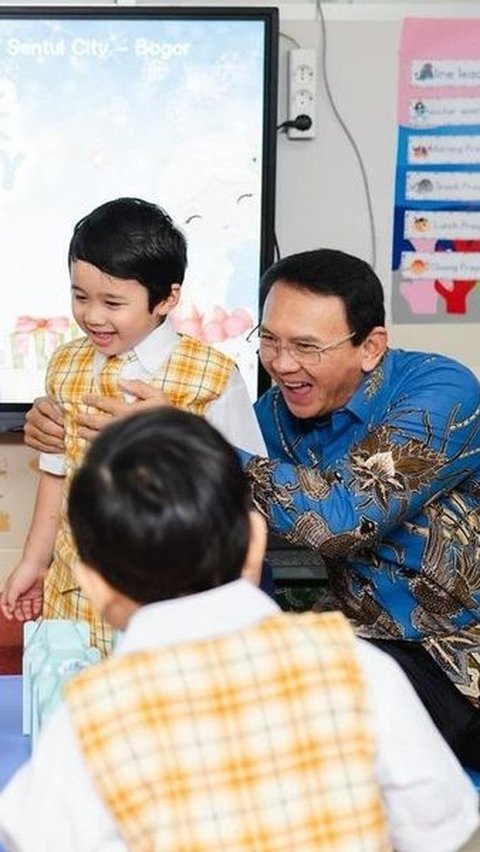 Ahok Memegang Anak Laki-Lakinya Agar Tidak Ikut Meniup Lilin